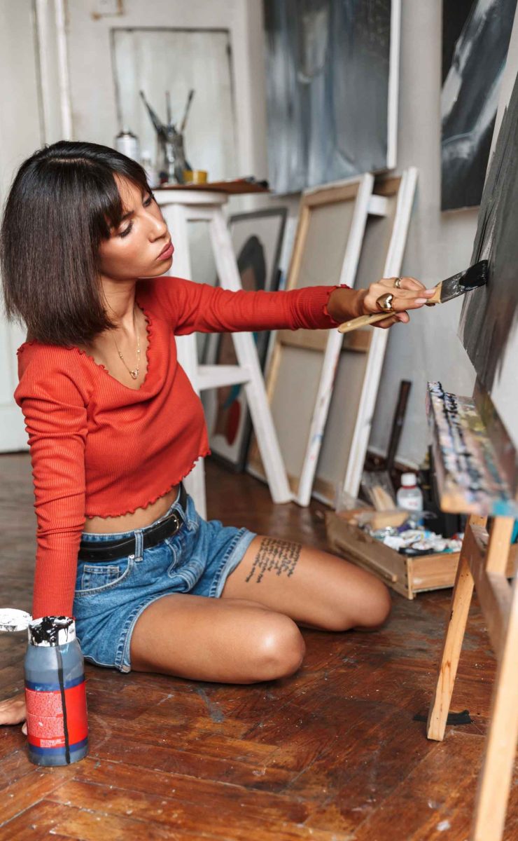 portrait-of-young-woman-using-painting-tools-while-KZHY4GP.jpg